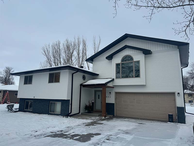 Snow-covered Horace, ND house with new vinyl siding and roofing installed by a local contractor.